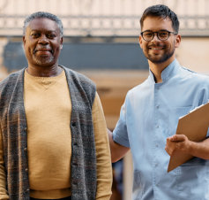 caretaker and elderly man smile